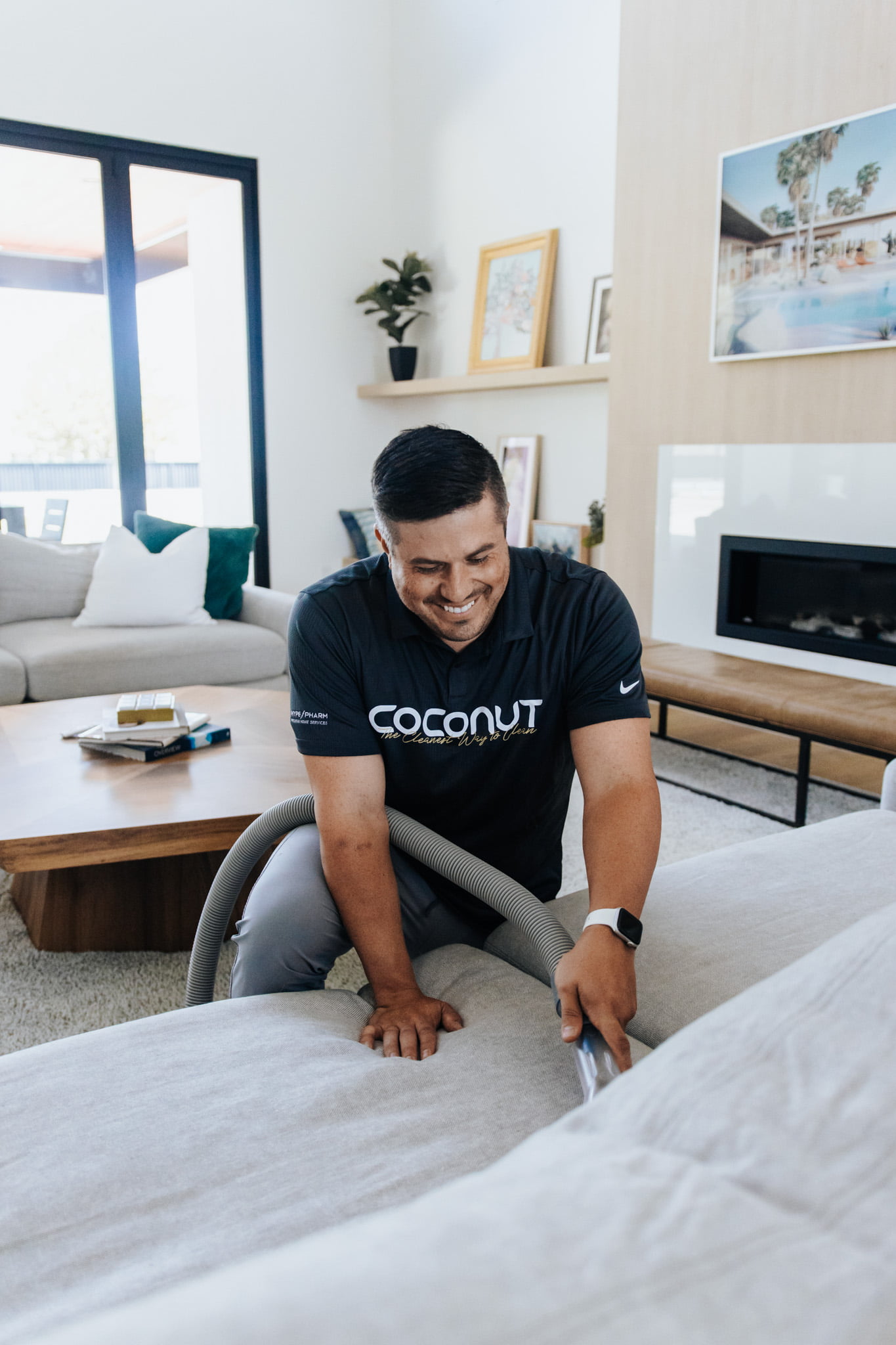 Coconut Cleaning specialist smiling while deep cleaning couch.