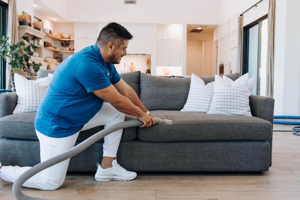 man performing furniture upholstery cleaning