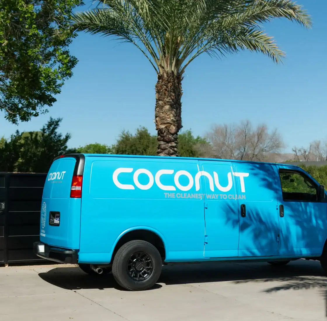 Coconut Cleaning branded service van parked outside a home