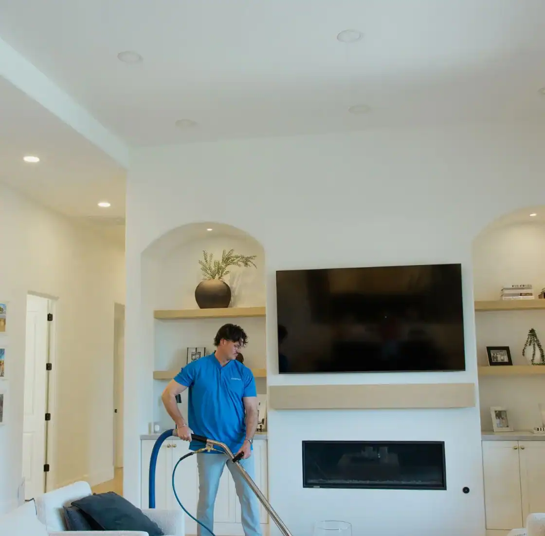 Coconut Cleaning technician deep cleaning a living room carpet with a hot water extraction wand