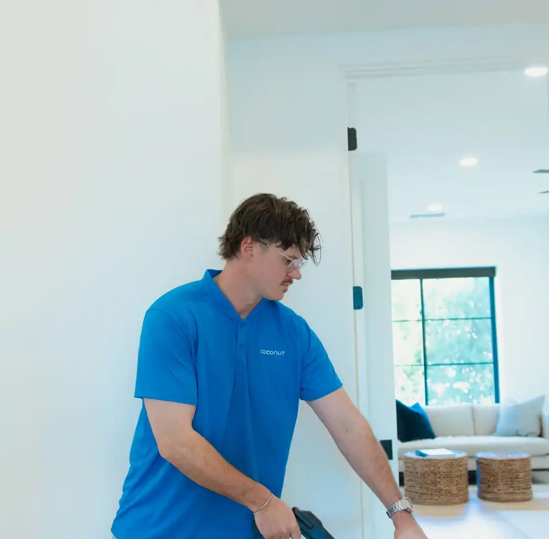 Coconut Cleaning technician guiding a carpet extraction wand across a home floor