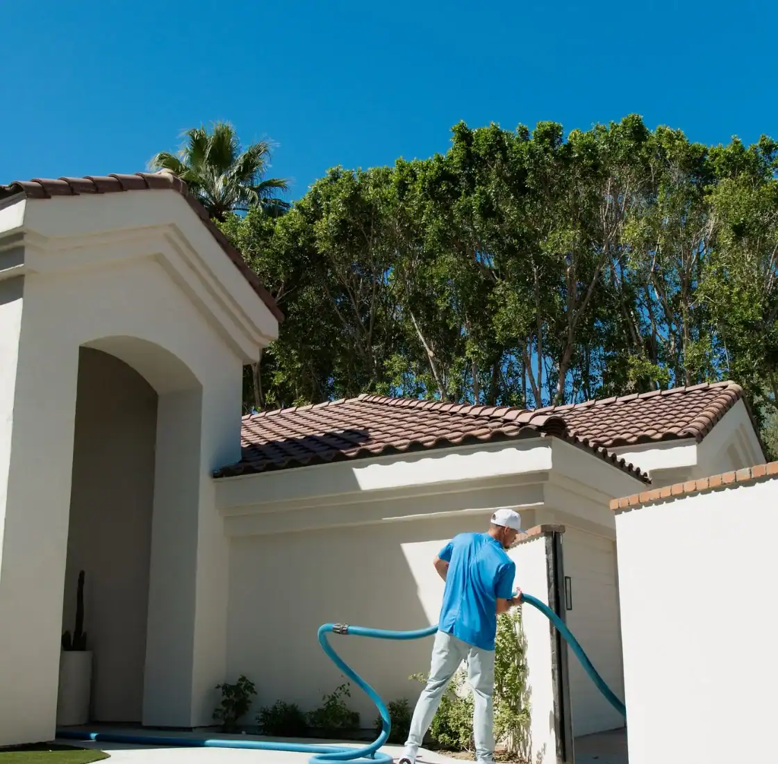 Technician feeding the cleaning hose through a home entryway