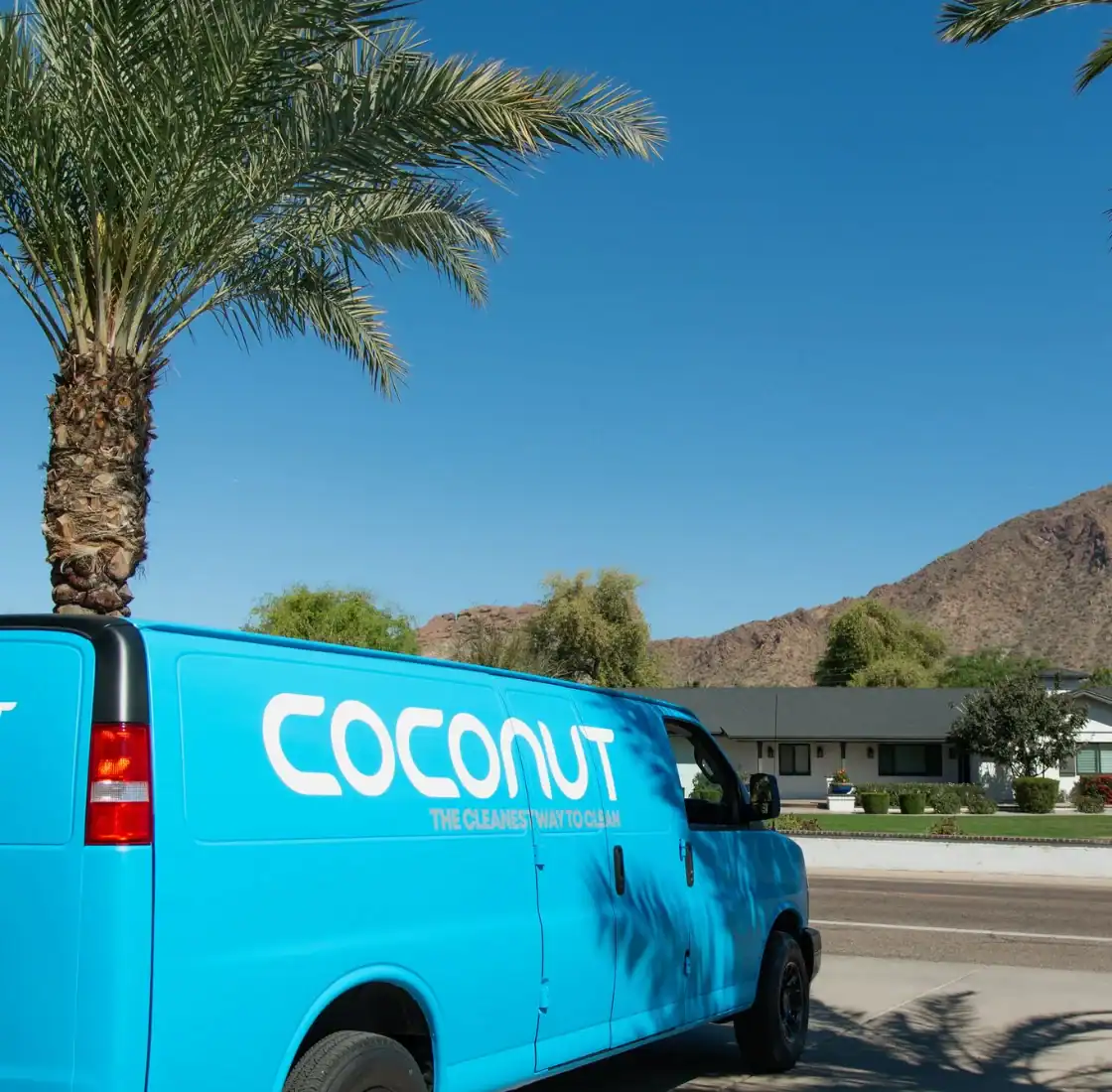 Coconut Cleaning service van parked on a residential street