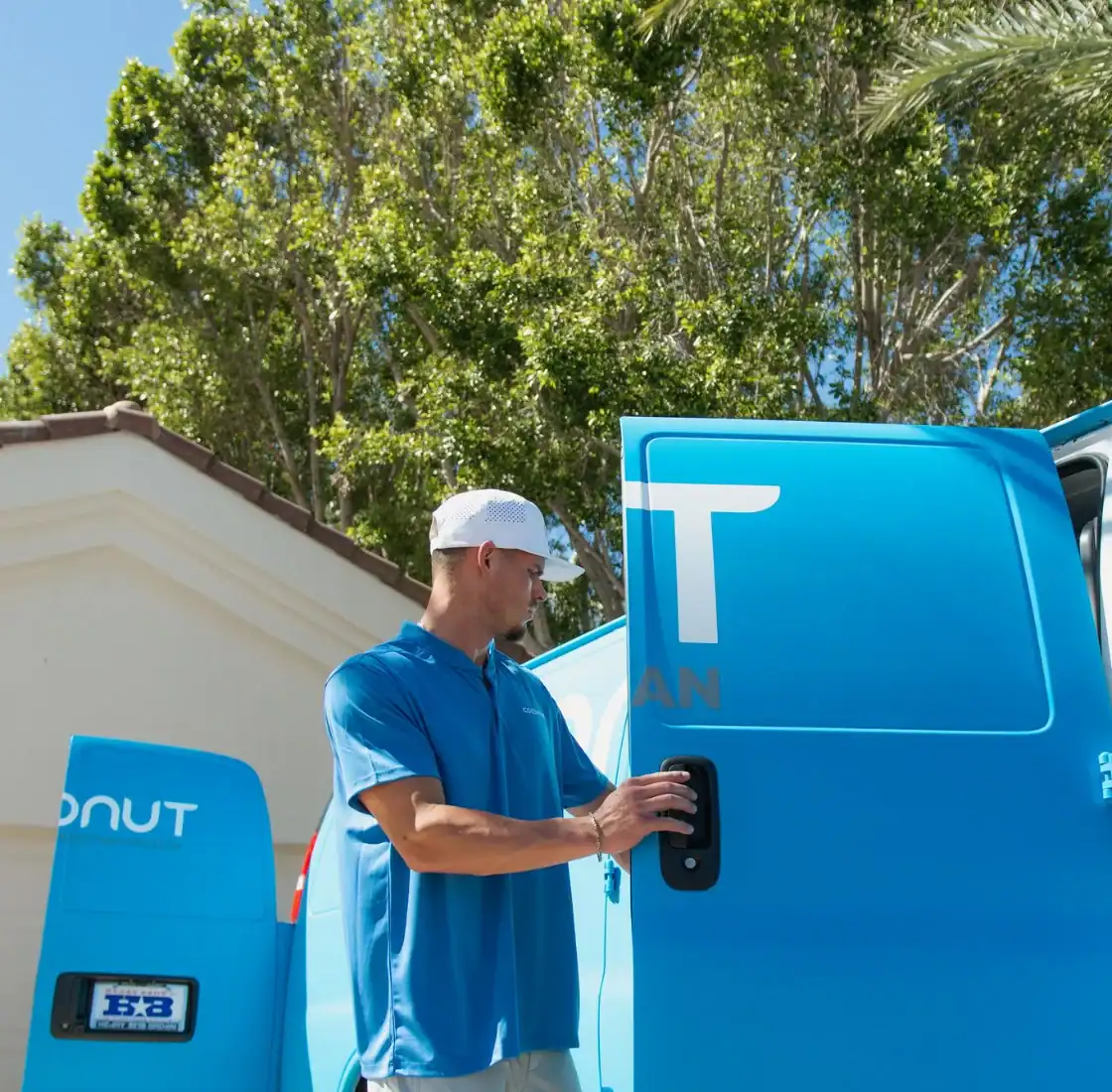 Coconut Cleaning technician at the side door of the service van