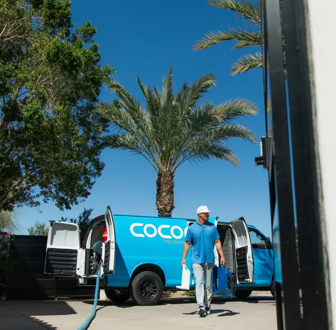 Coconut Cleaning technician carrying equipment from the service van to a job