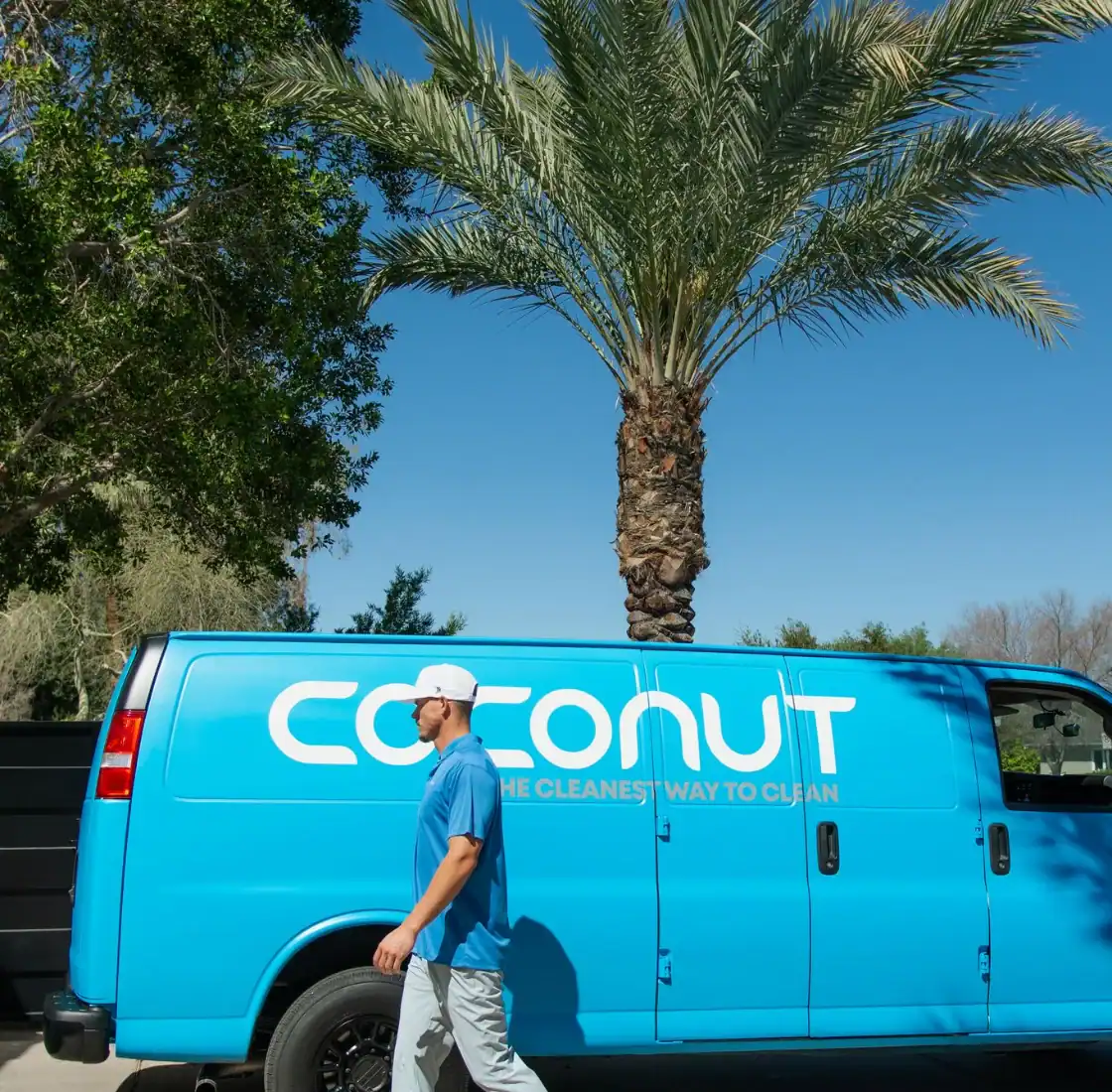 Coconut Cleaning technician walking past the branded service van