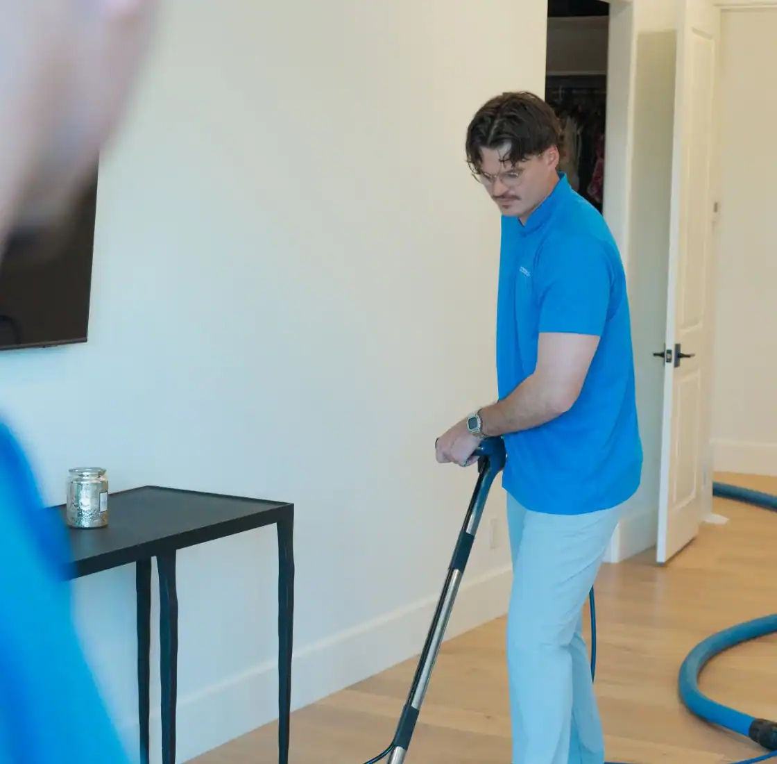 Technician working an extraction wand across a home floor