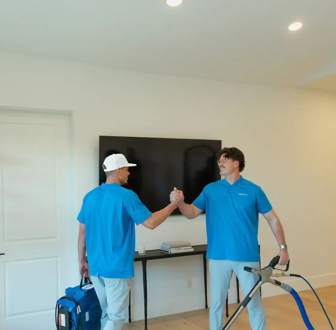 Two Coconut Cleaning technicians shaking hands after finishing a job